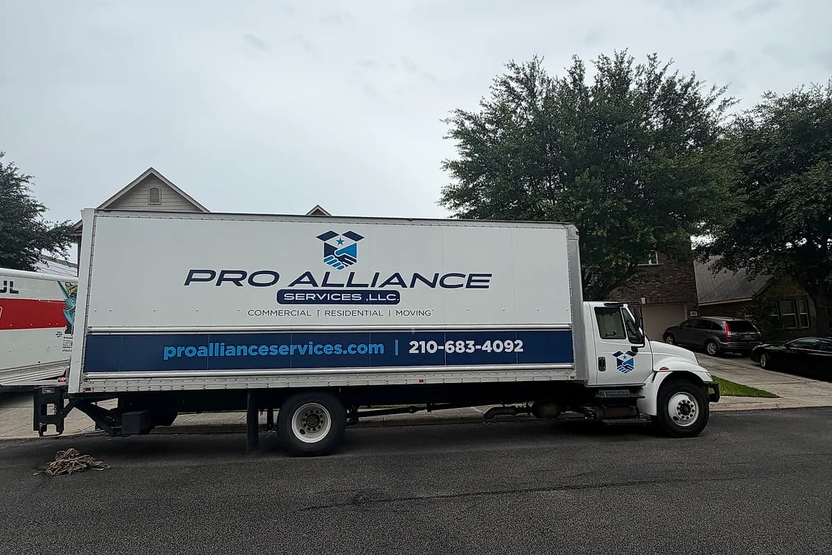 Pro Alliance Services box truck parked along the curb of a San Antonio residential street