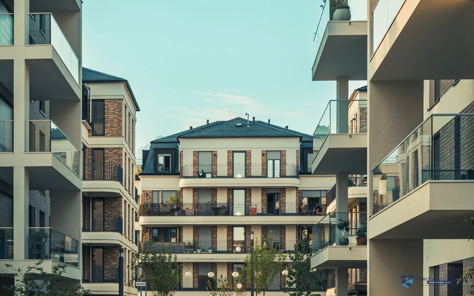 A modern multi-story apartment building with rows of balconies seen from the street