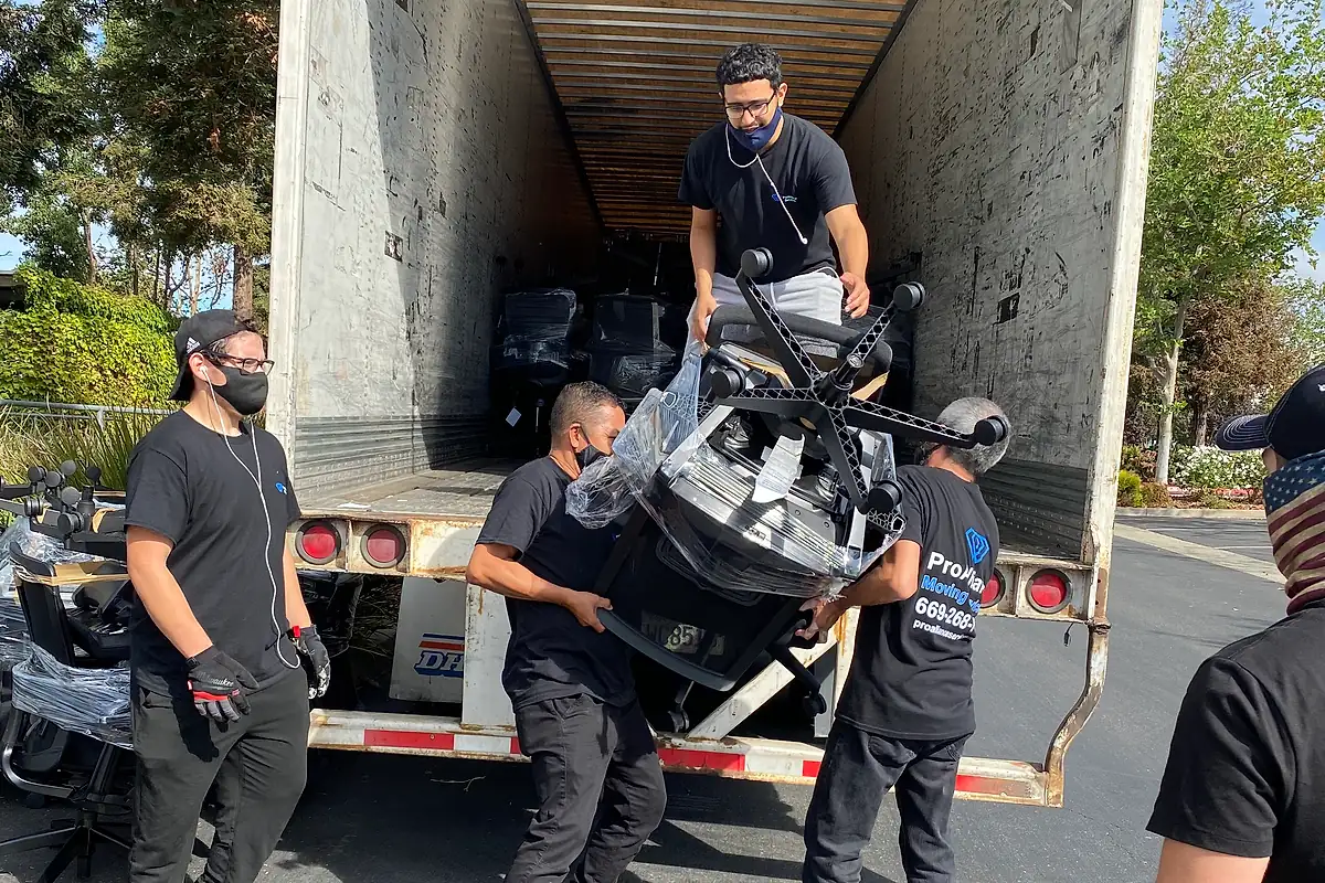 Pro Alliance crew loading wrapped office chairs into a trailer to keep an office move moving quickly