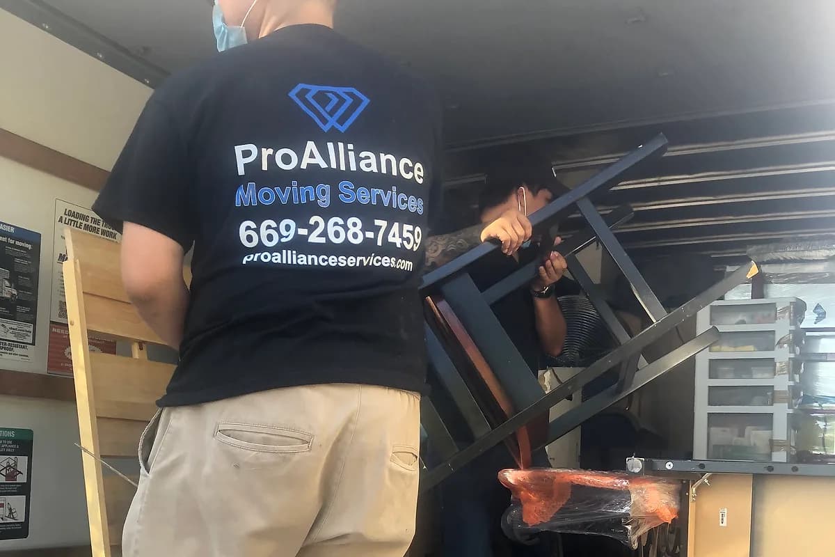 Pro Alliance mover loading fixtures and furniture into a truck during a commercial relocation