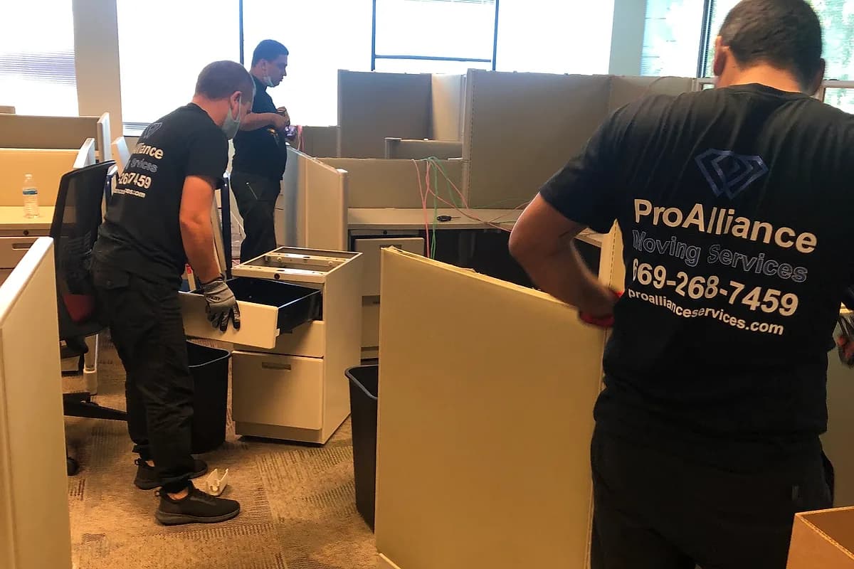 Pro Alliance crew clearing filing cabinets and workstation contents ahead of a workspace relocation