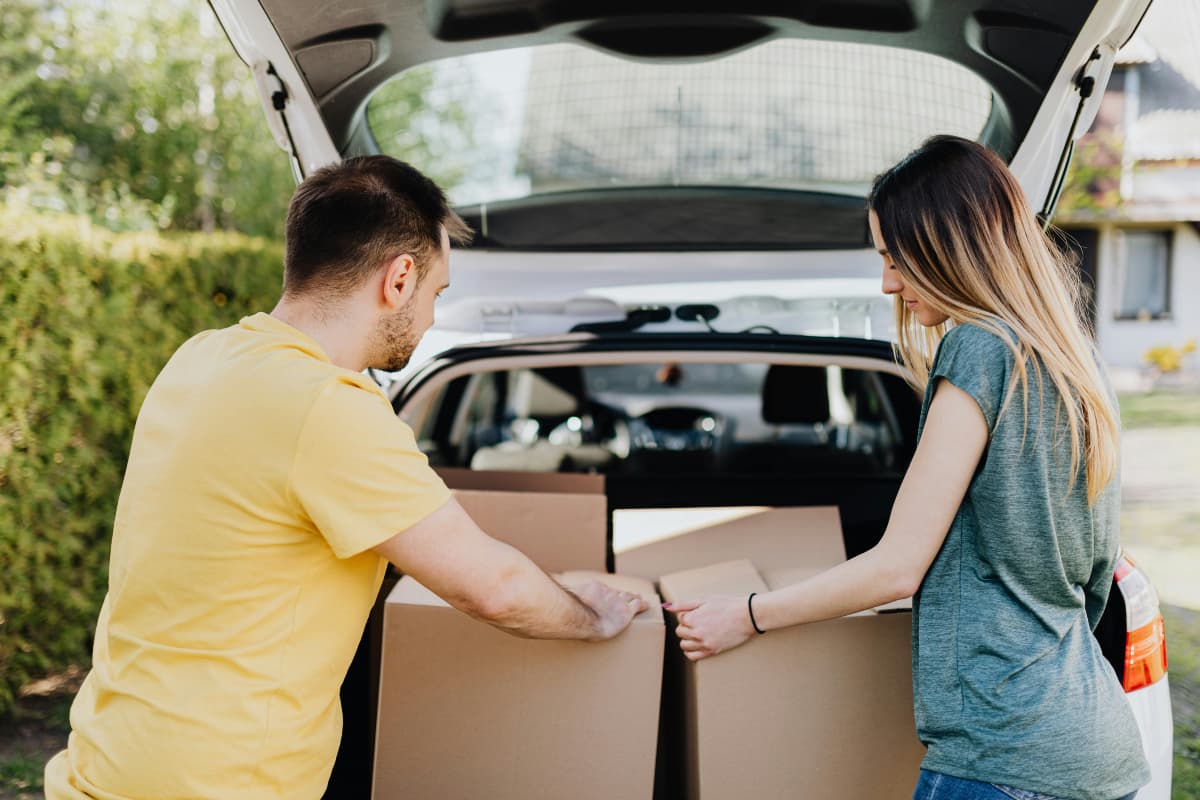 people putting boxes into a car