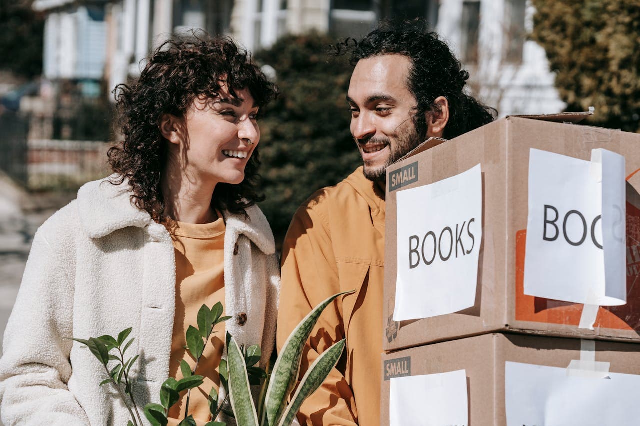 Couple carrying moving boxes