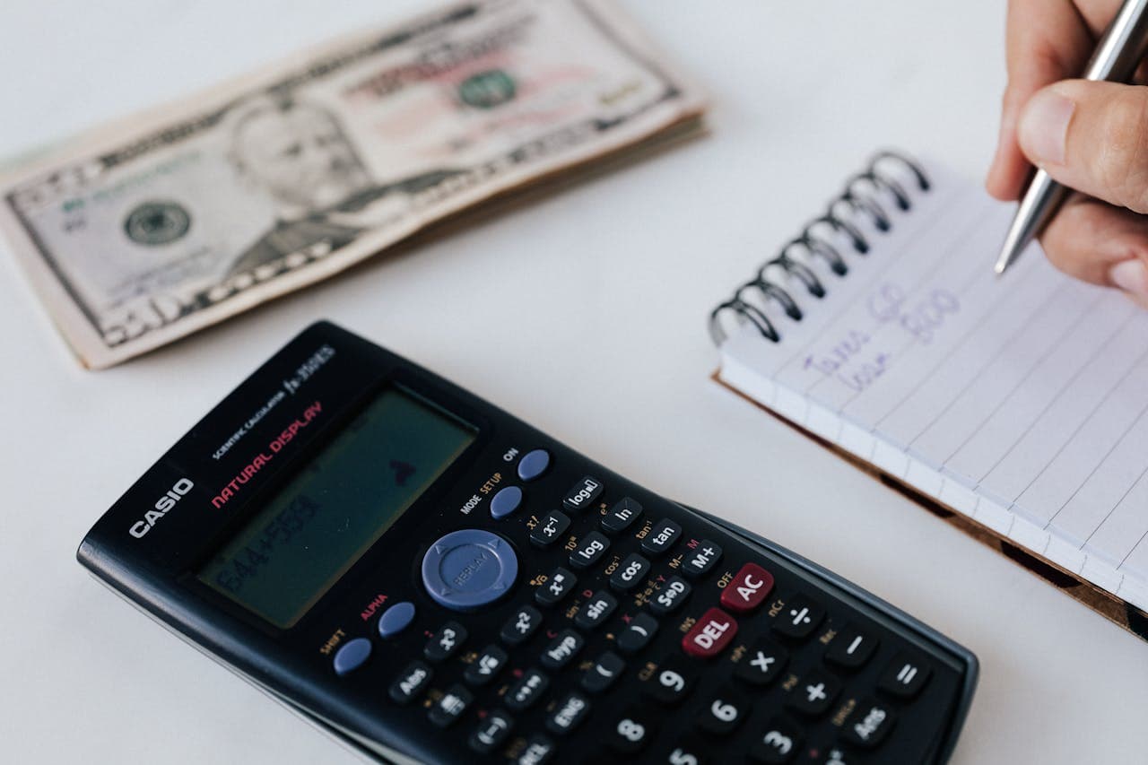 A person calculating dollar bills for a budget-friendly moving in Garden Ridge