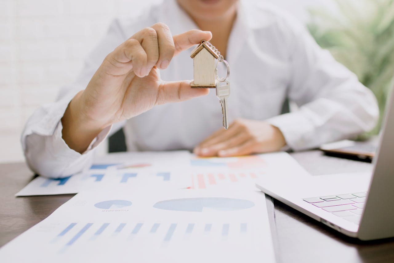 A person holding a key exploring buying a home in San Antonio vs neighboring cities