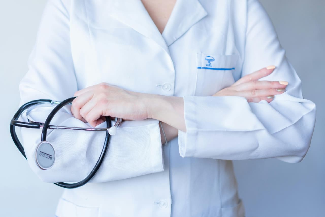 Healthcare professional holding a black stethoscope during office preparation