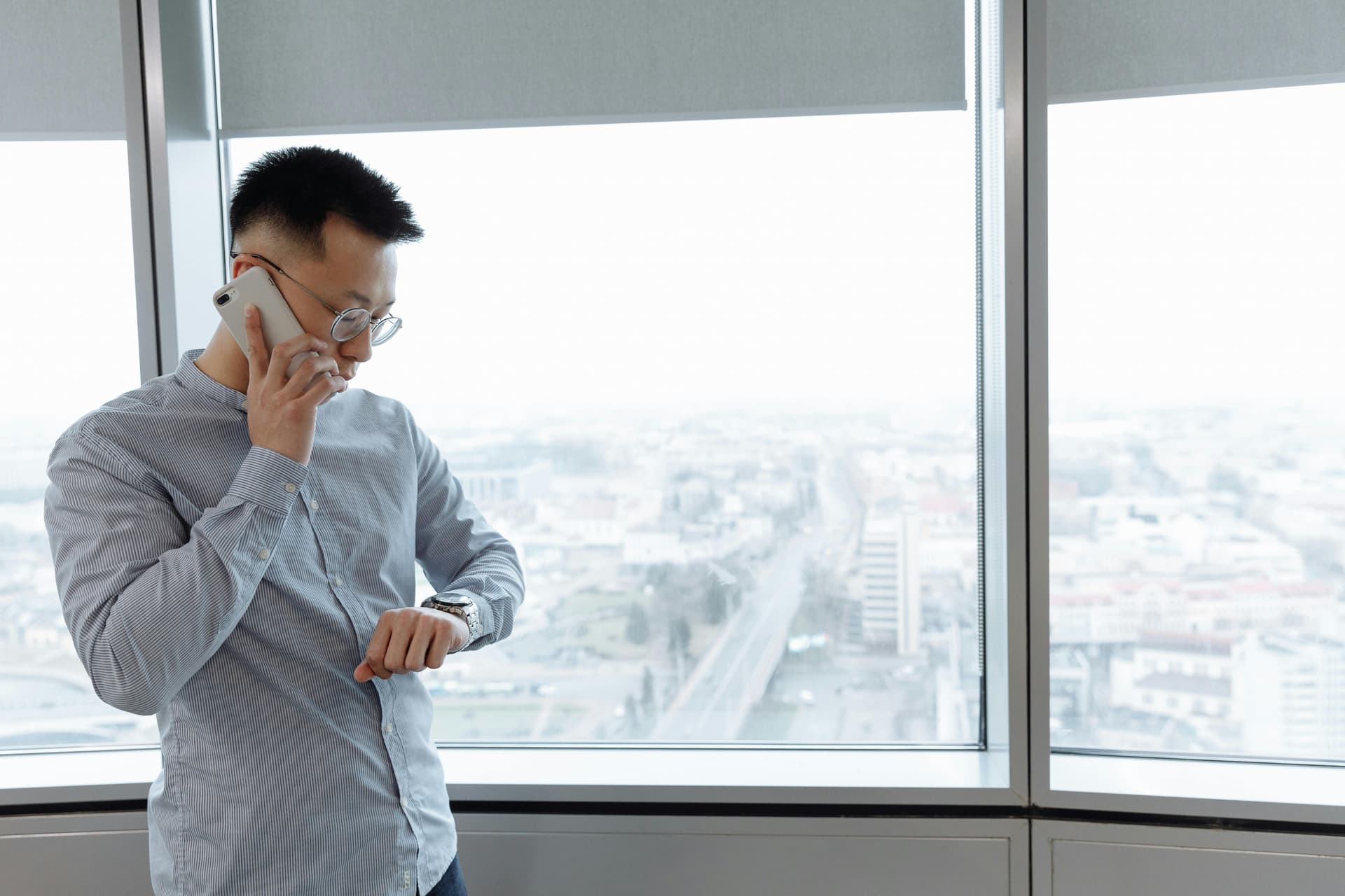 A Man Having a Phone Call while Looking at His Watch
