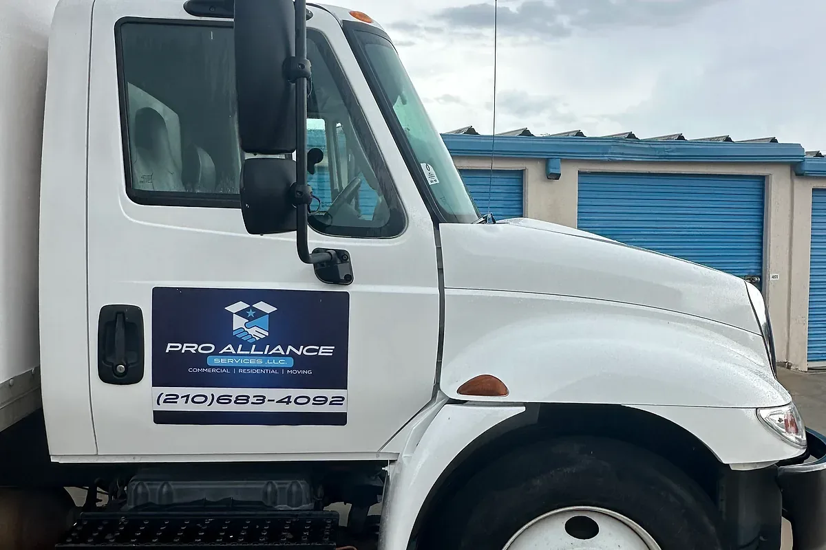 A moving truck parked near gated multi-unit housing