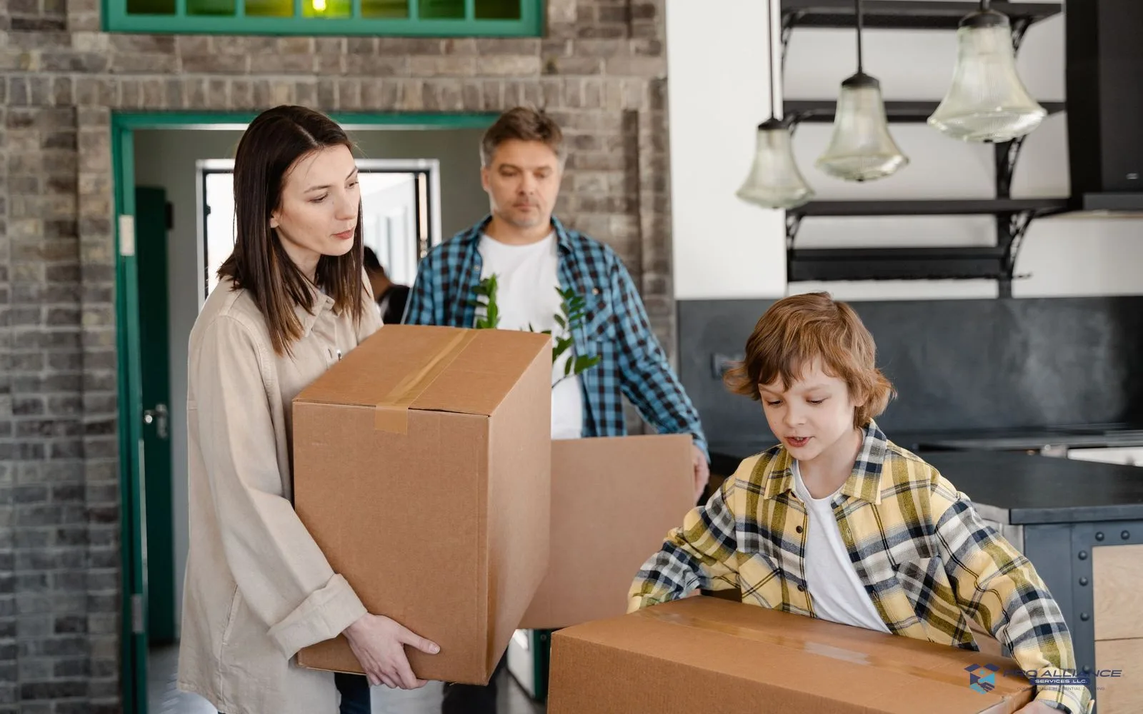 A family carrying cardboard boxes into a house through the front door