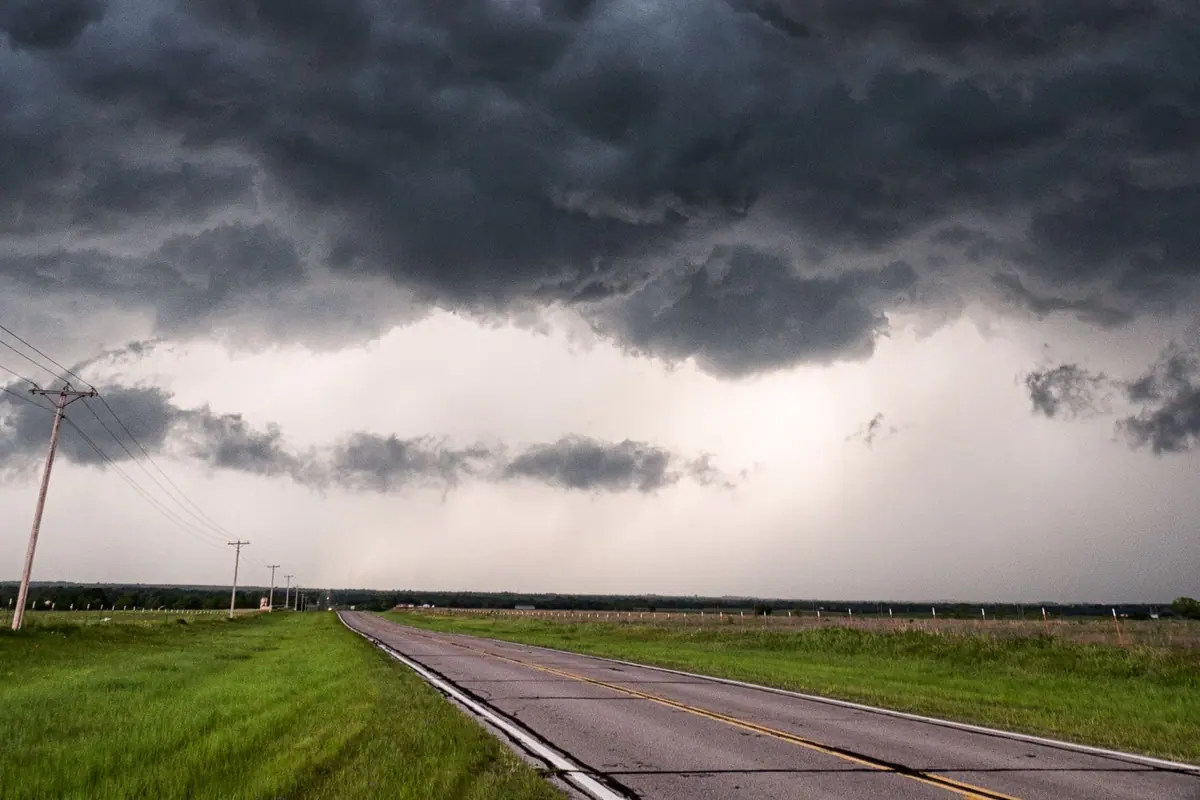 Rural road beneath changing weather conditions