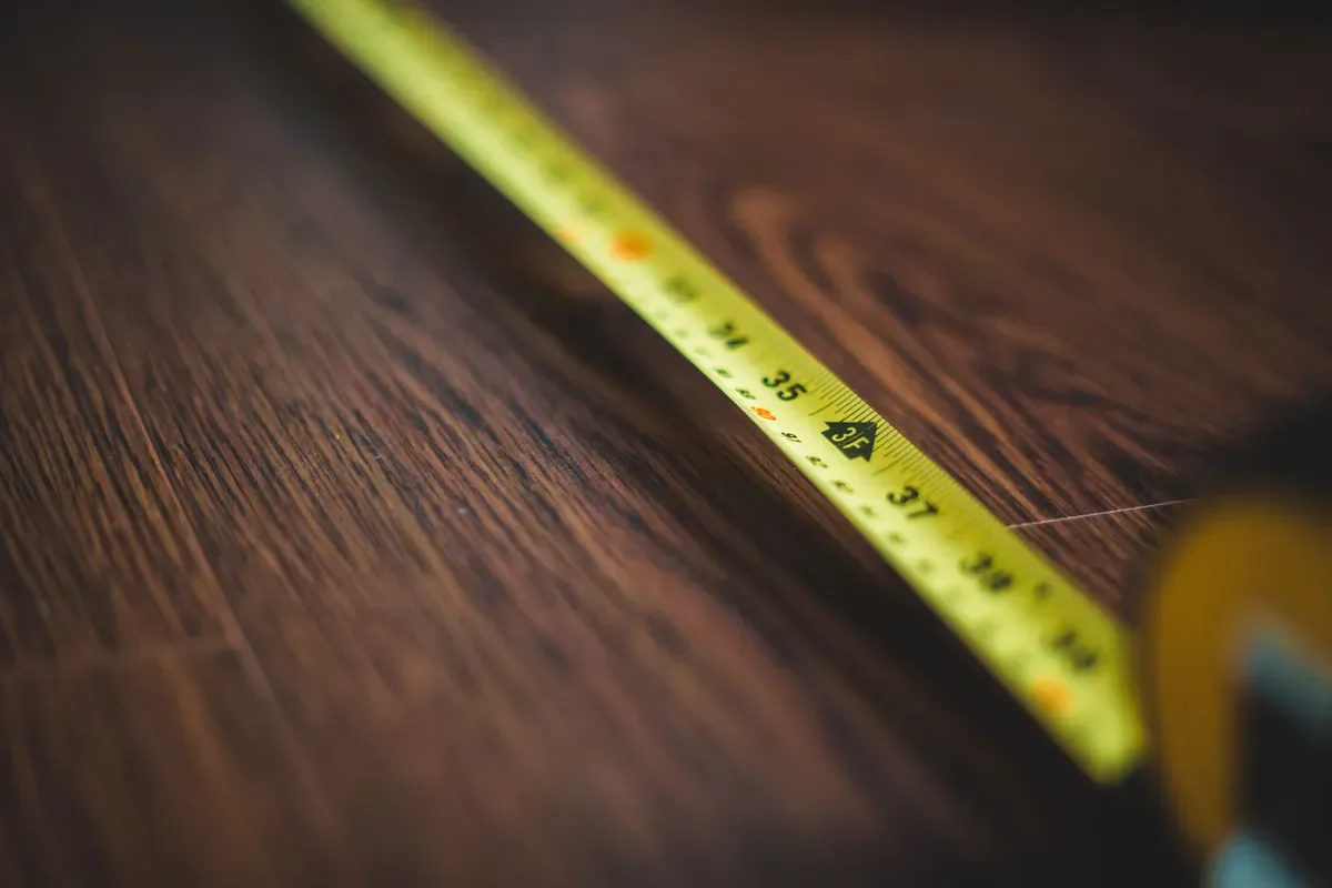 A tape measure extended across a wood surface