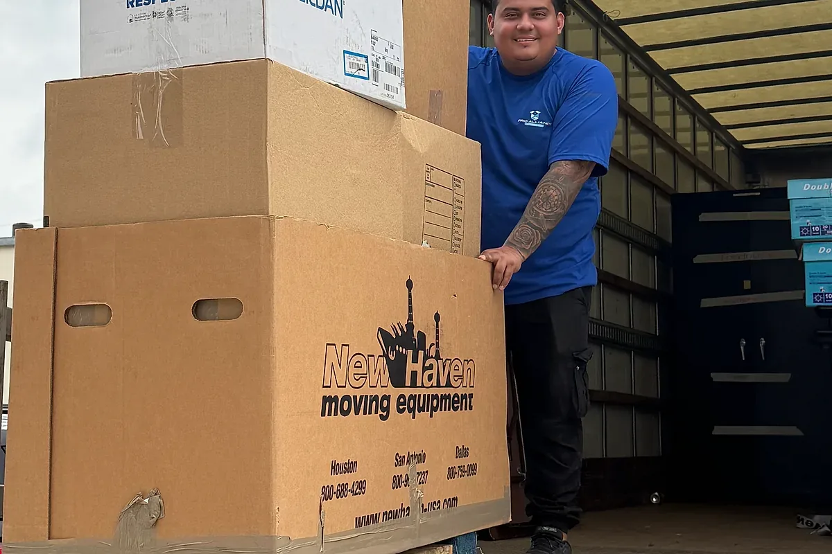 Organized moving cartons stacked near a dolly