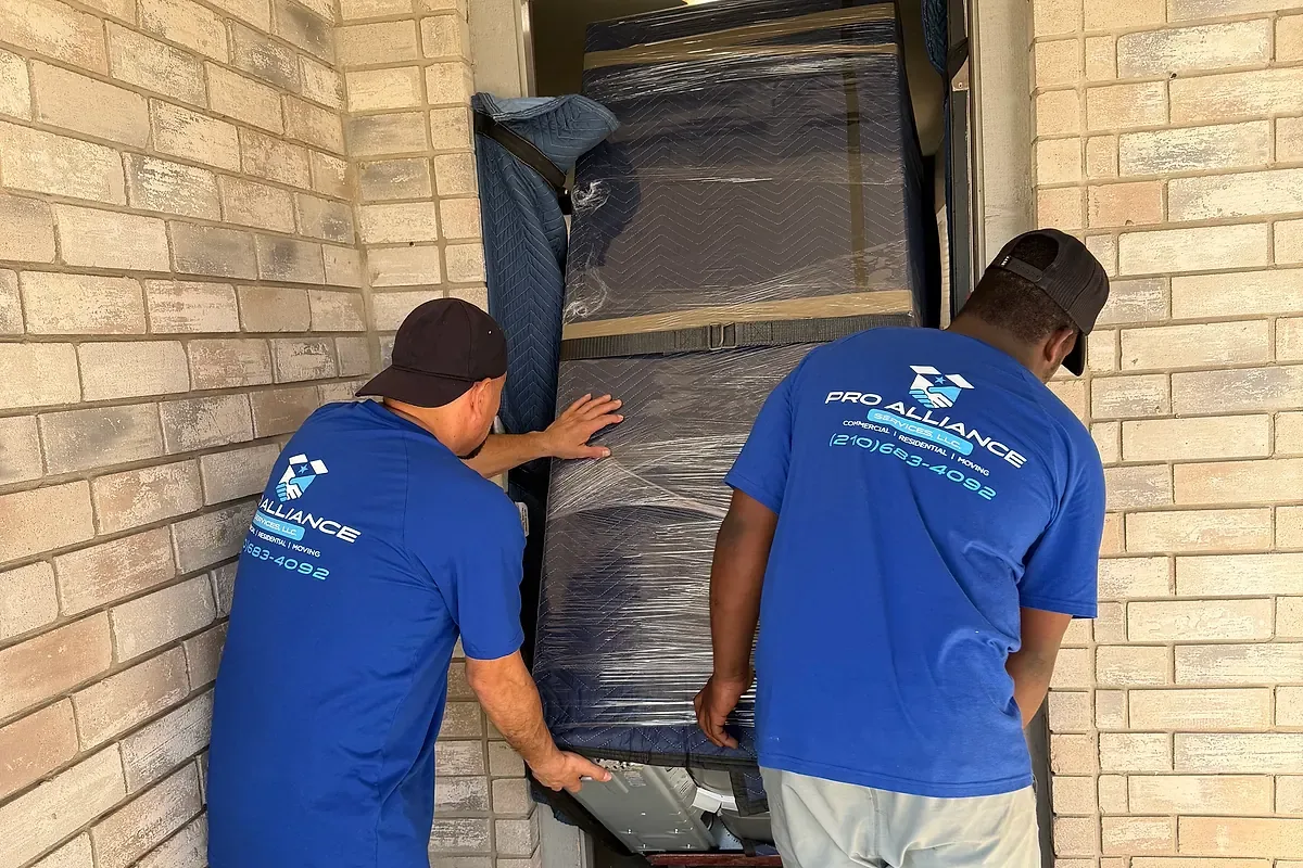 A wrapped furniture item checked for clearance at a front doorway