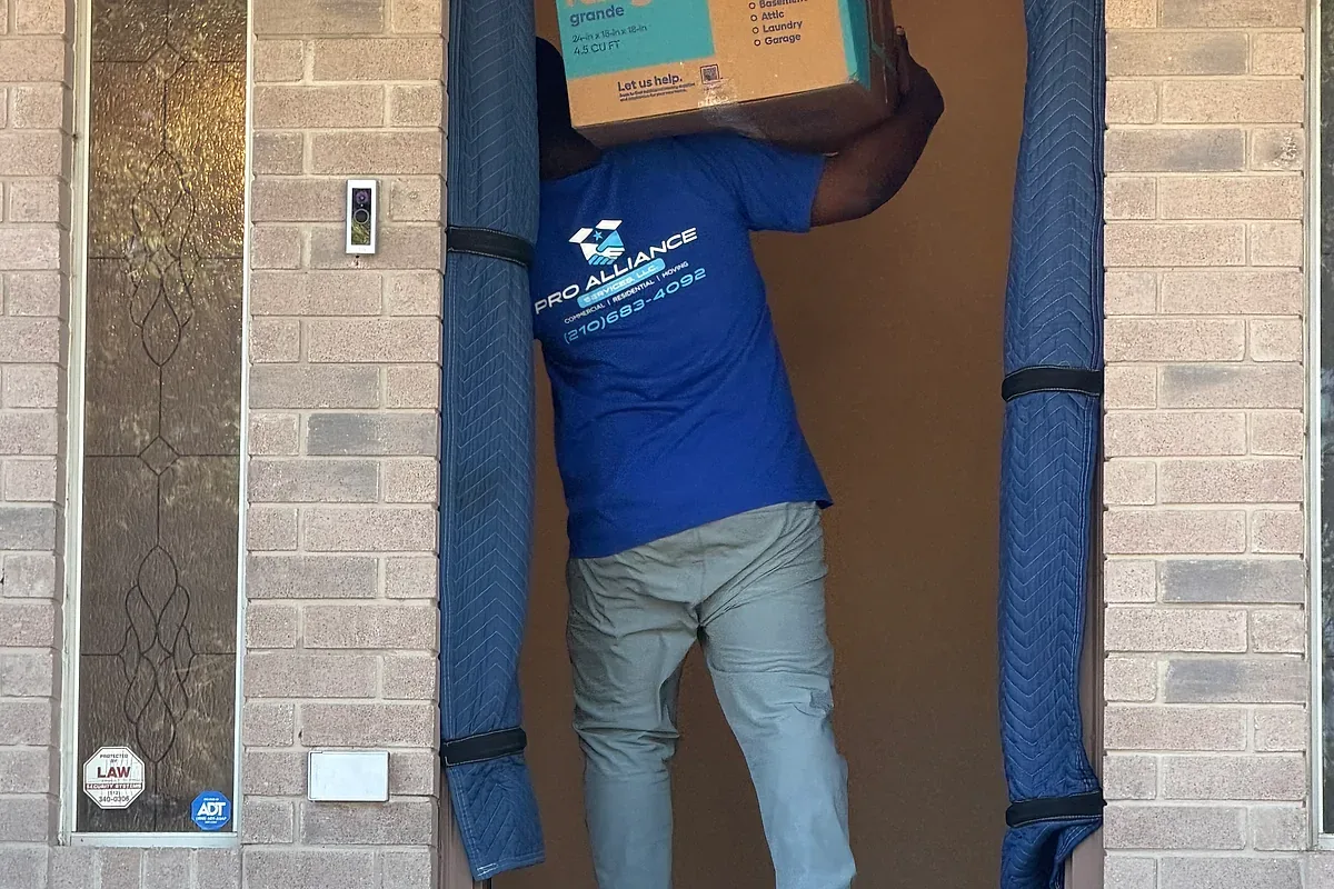 A carton carried through a doorway protected with padding