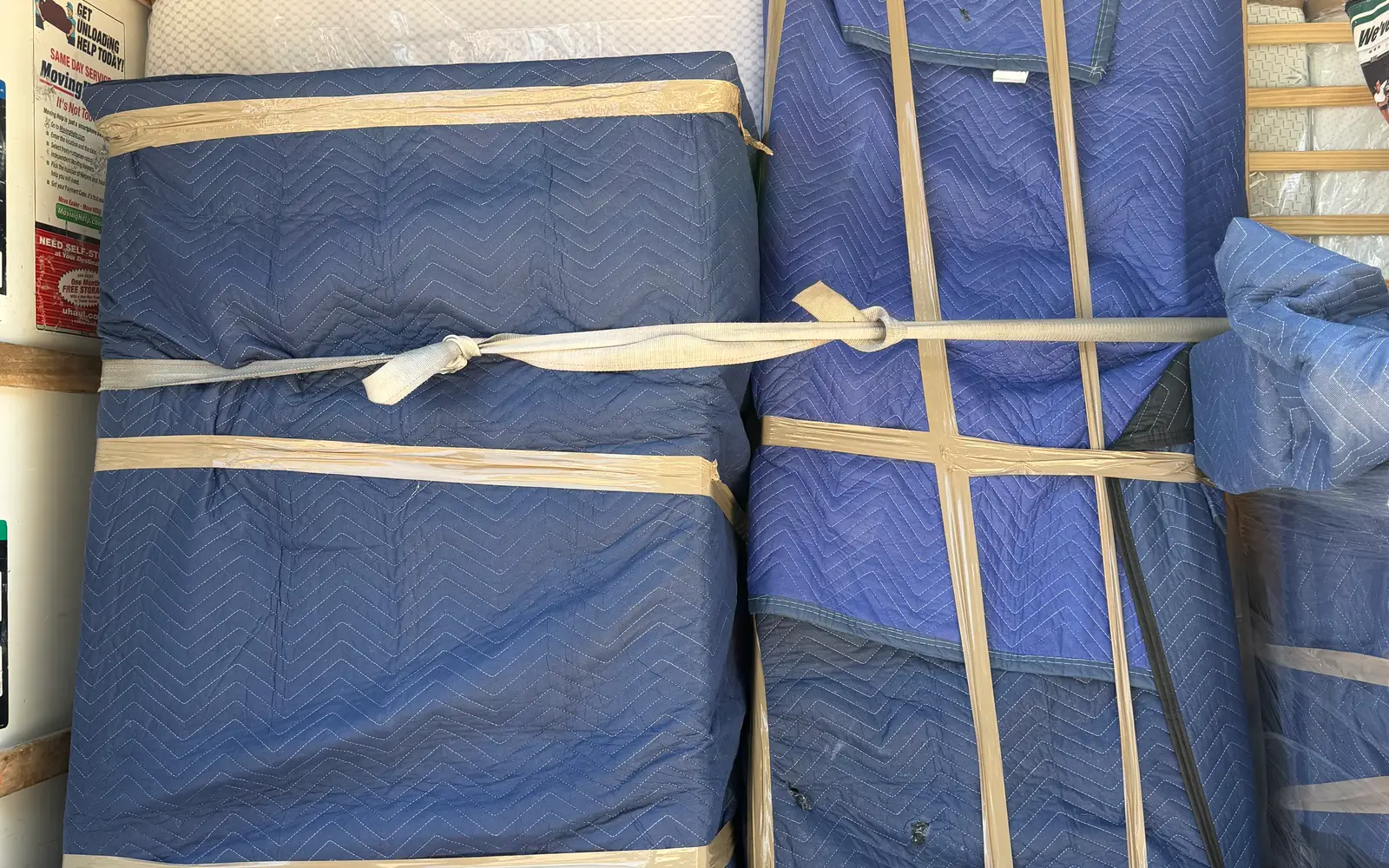 Blanket-wrapped furniture strapped upright inside a Pro Alliance moving truck