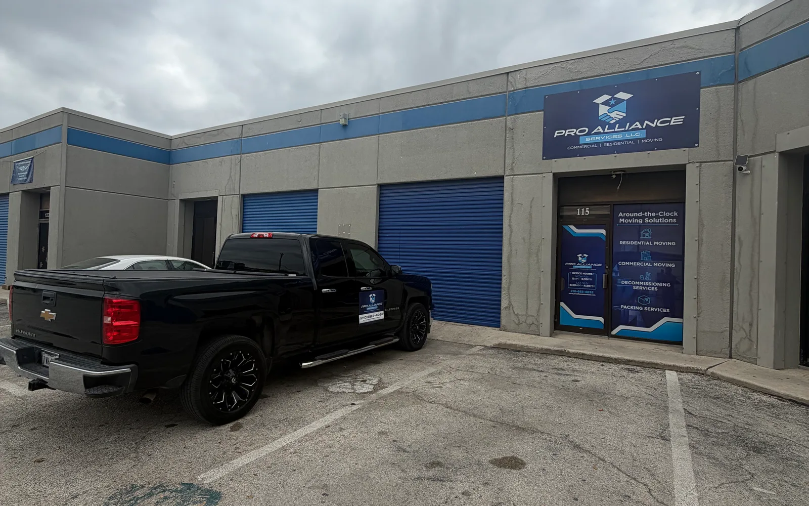 The exterior of the Pro Alliance warehouse unit with signage and a company pickup truck parked outside