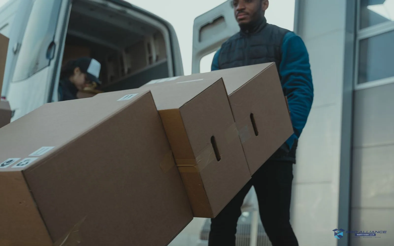 A hand truck loaded with boxes at a building entry