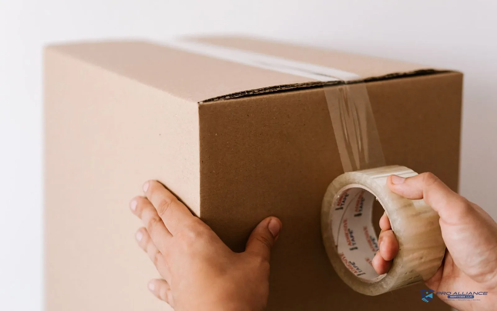 Moving boxes and packing tape in use mid-pack in a living room