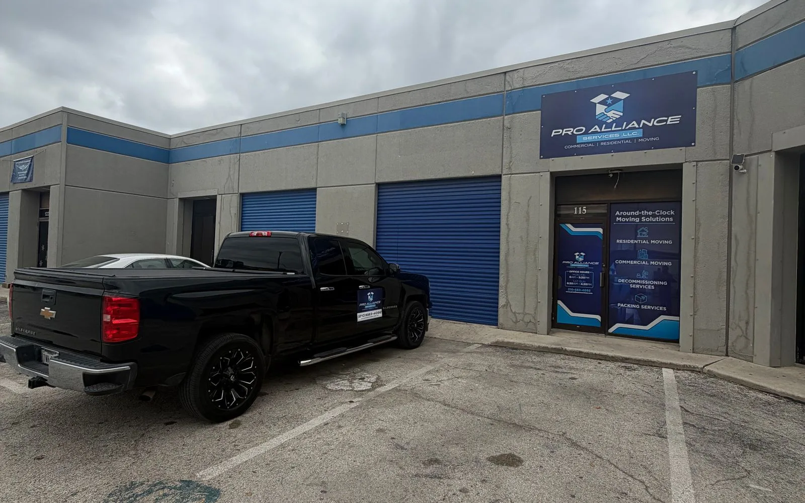 The exterior of the Pro Alliance warehouse unit with signage and a company pickup truck