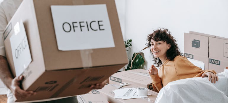 Woman smiling as office boxes are packed during a corporate relocation to Helotes.