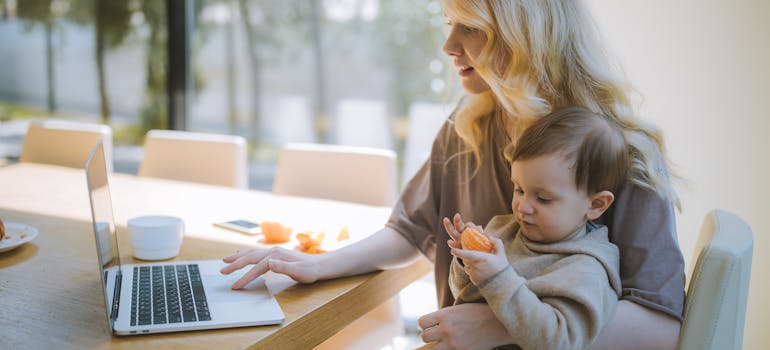 A mother with a baby using a laptop