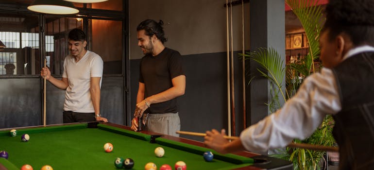 People next to the pool table talking about how climate changes affect your pool table