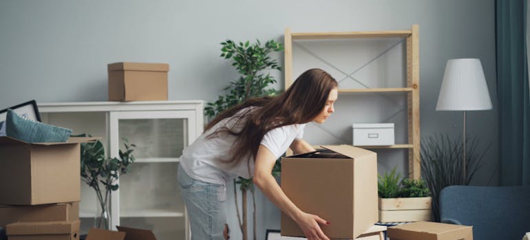 A woman holding a moving box