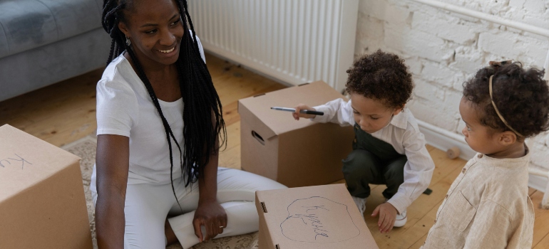 Mom and Toddlers Labeling Cardboard Boxes on the Floor While They Pack for a Move, When You Have a Toddler at Home