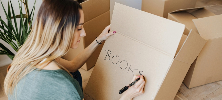 woman writing on cardboard container word book
