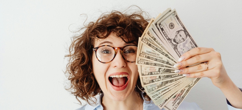 Happy Woman in Blue Long Sleeve Blouse Holding Money