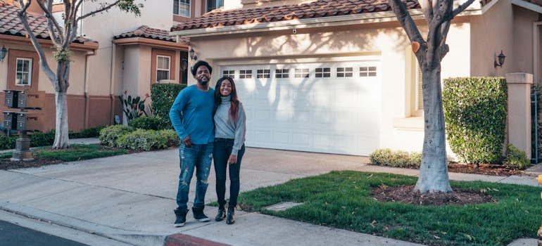 a couple standing in front of their home
