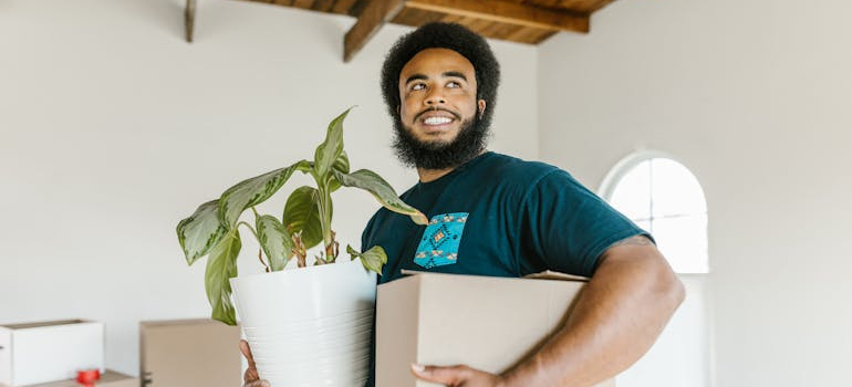 a mover holding a box and a pot, summer move from Schertz to Cibolo