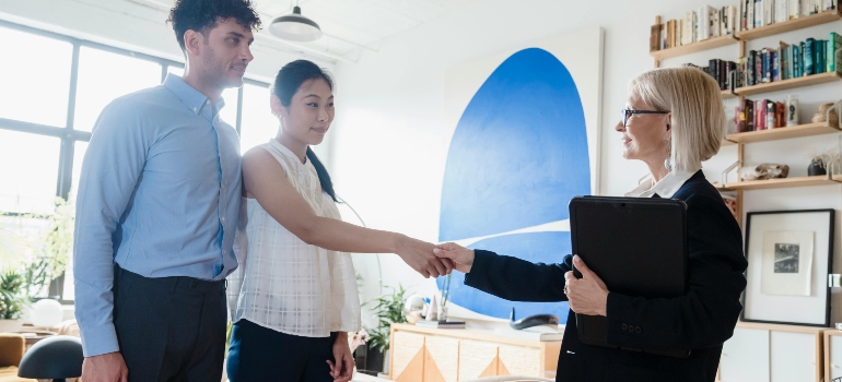 Young Couple shaking hands with agent