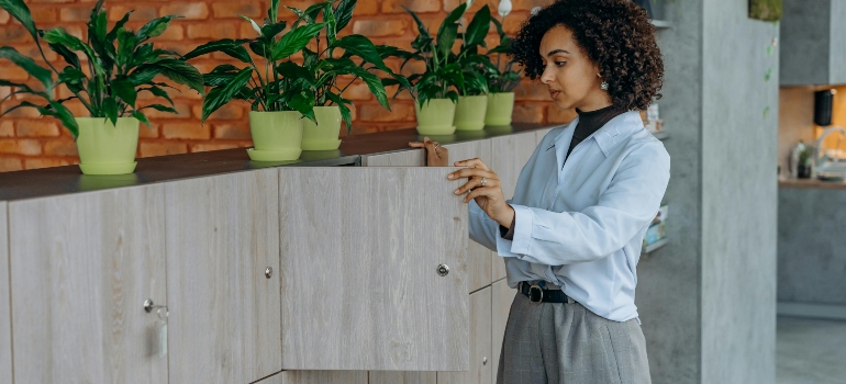Curly Haired Woman Opening a Wooden Locker