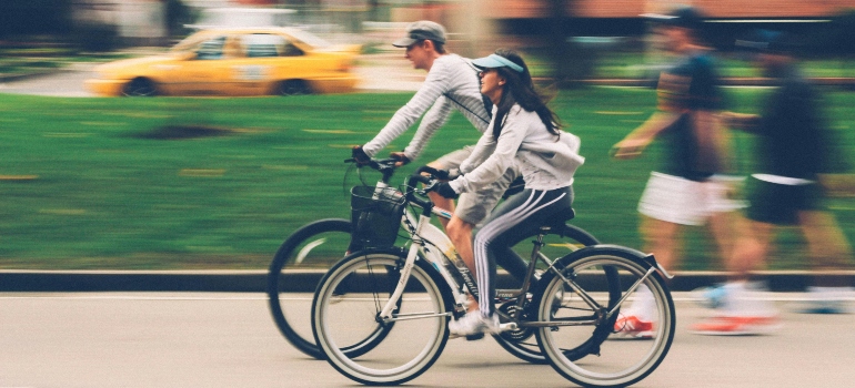A woman and man riding bikes together, showcasing the lively cities in Bexar County for an active lifestyle.