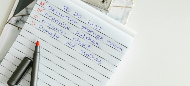List Written in a Notepad With Pen showing steps for decluttering your workspace before relocating in San Antonio efficiently