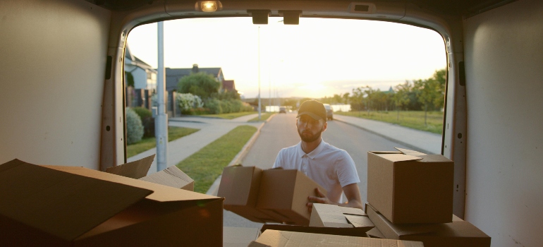 A man is packing boxes into a van.