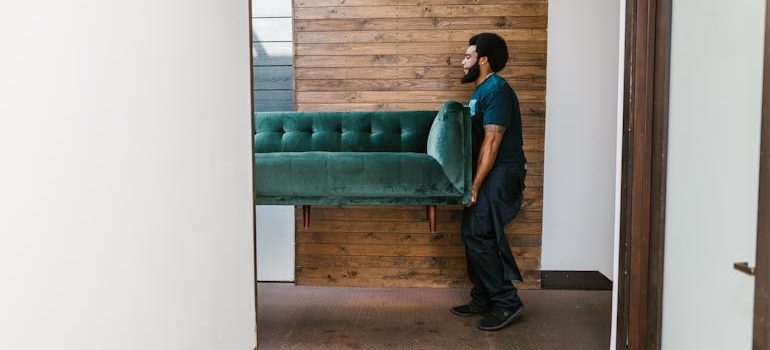 Moving professionals carefully carrying a piece of furniture, demonstrating the skill and care of Uvalde movers during residential and commercial relocations.