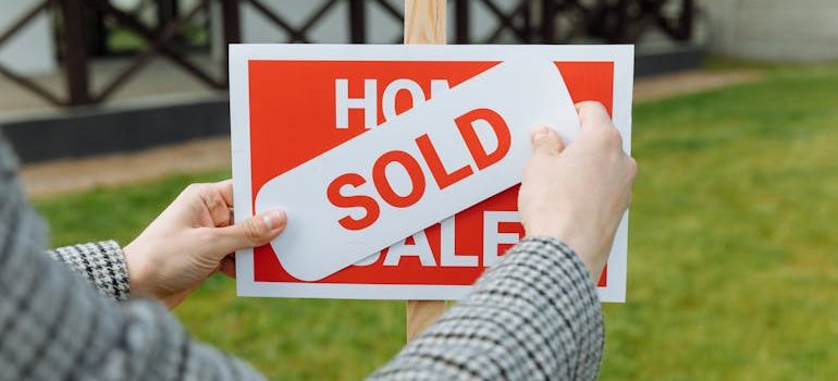 A realtor posting a SOLD sticker in the Spring Branch housing market.