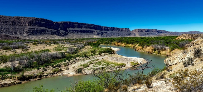 Body of Water Between 2 Mountains Under Clear Sky during Daytime