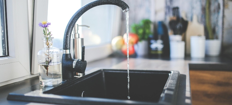 Kitchen sink running water as part of utility checks when moving from an apartment to a house.