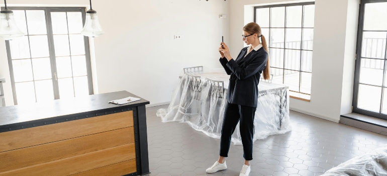 Woman documenting property condition before departure as part of a detailed moving to-do list.