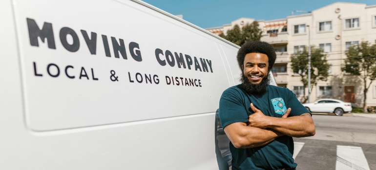 Professional mover beside truck specializing in moving a grand piano long distance.