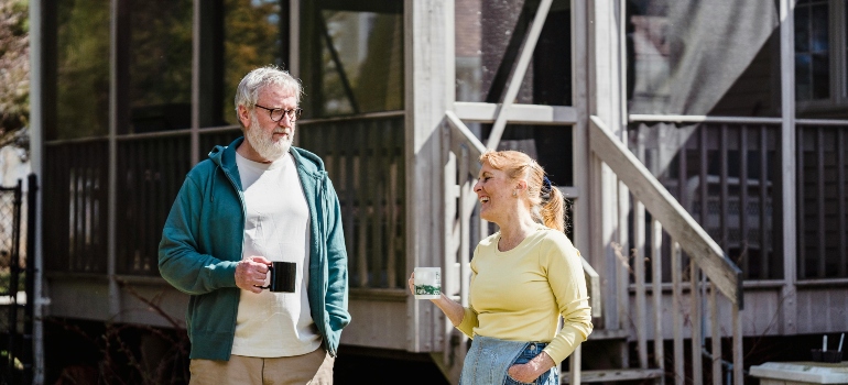 Neighbors chatting outside a home as part of settling into small-town life.