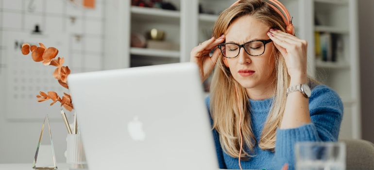 Woman feeling stressed while researching how to avoid moving fraud in Hondo online