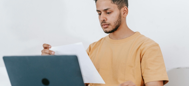 Person checking moving documents before hiring a moving company in Fredericksburg.