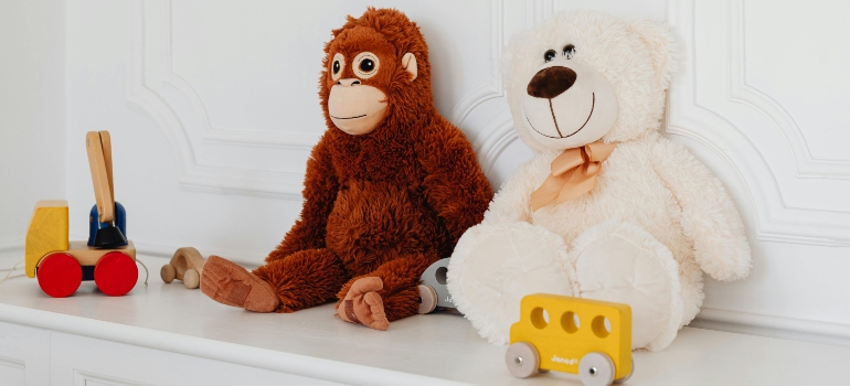 Animals and small toys arranged on shelf representing how to pack toys for moving stuffed .