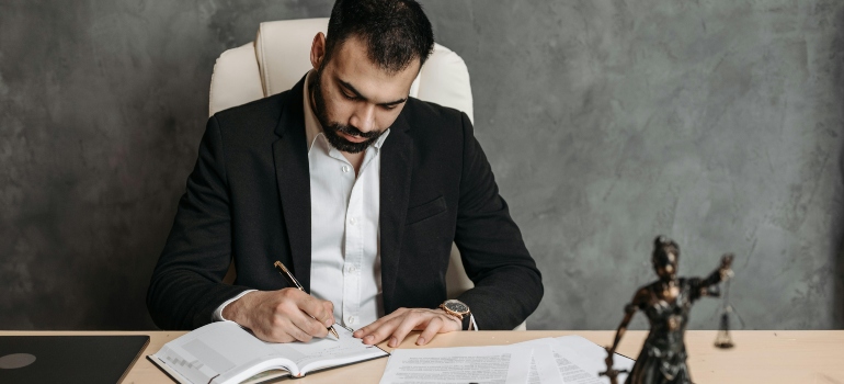 Business professional signing documents as part of what to consider when moving office locations.