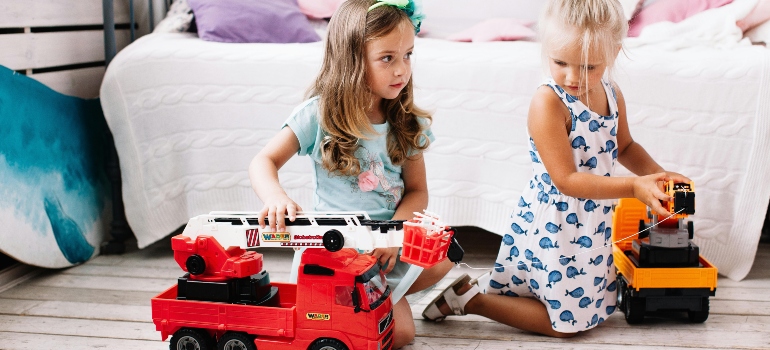 Children playing with toy trucks before packing toys for a move.