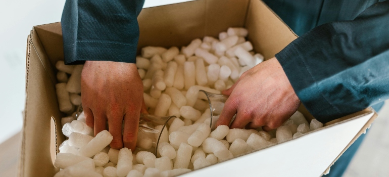 What are the types of packaging materials packing peanuts cushioning glass items in box.